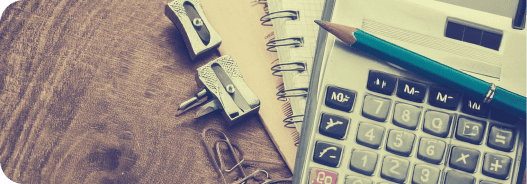 Calculadora e materiais escolares sobre uma mesa, representando o estudo de conceitos matemáticos como equações e geometria.